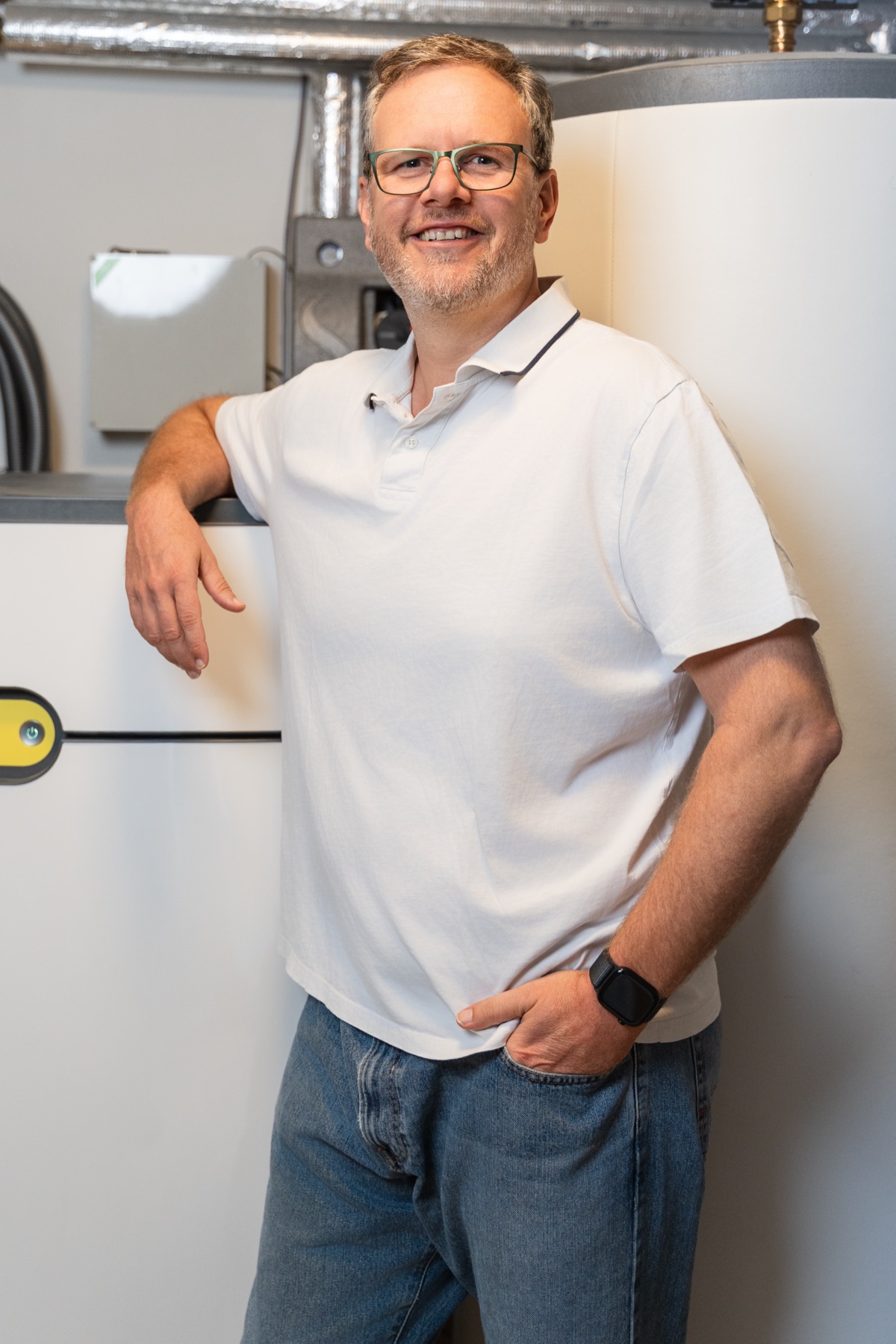 Christian Persch im Technikraum neben einem Pufferspeicher